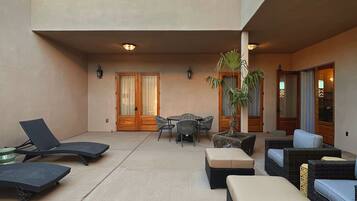 A spacious outdoor area with lounge chairs, a table, and a potted plant.