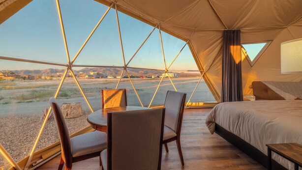 A tented accommodation with a bed, a table, and chairs, and a view of a landscape. - Tirrito Farm (Willcox)