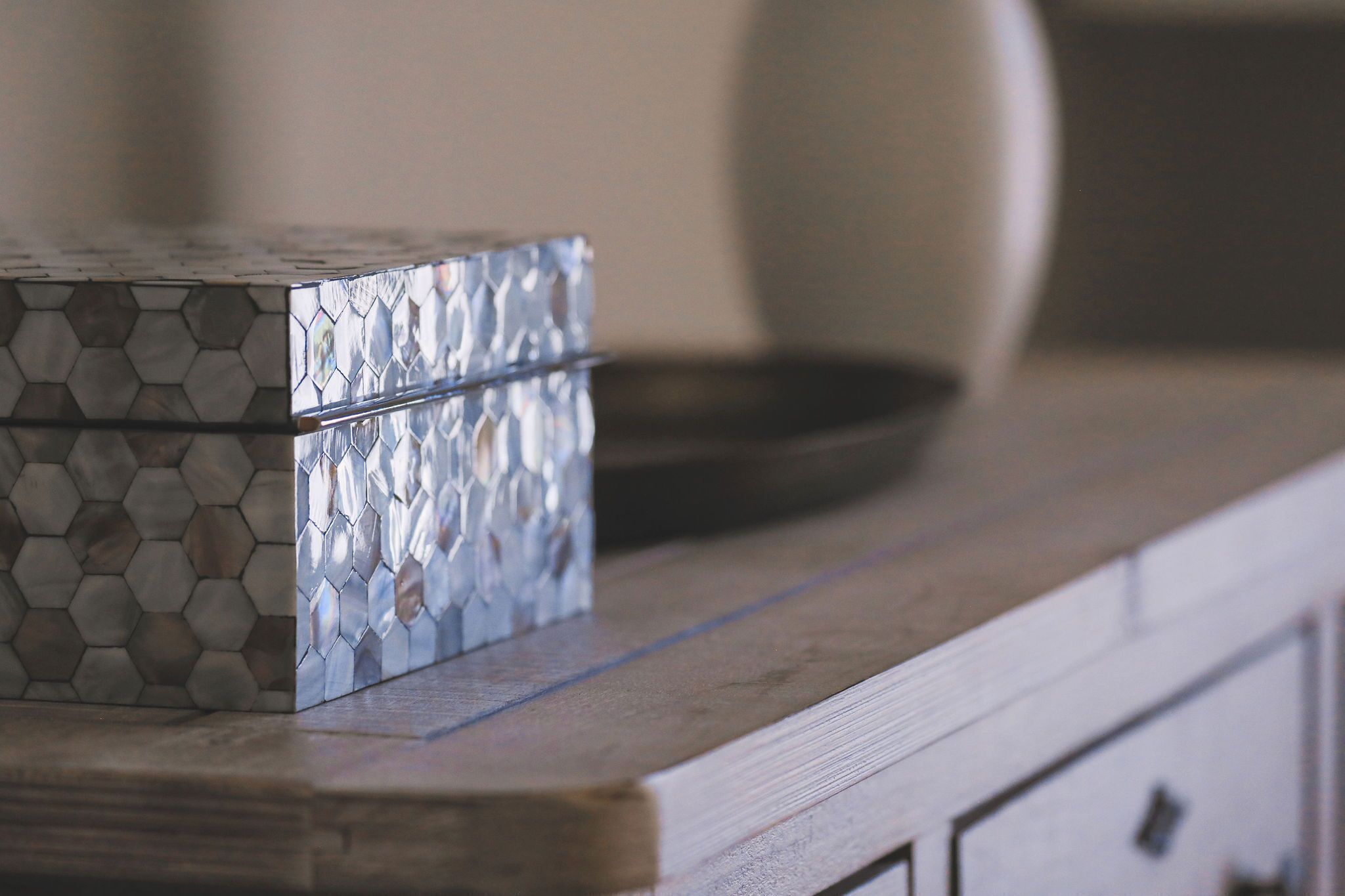 A metallic hexagonal box on a wooden countertop.