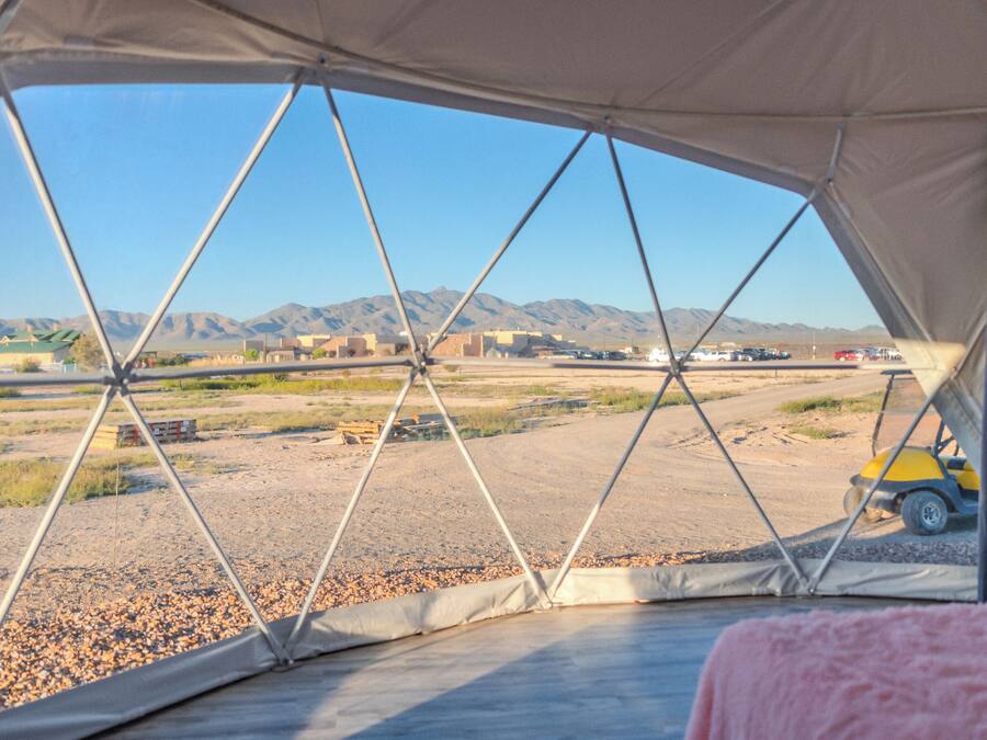 A tented area with a view of a desert landscape and mountains.