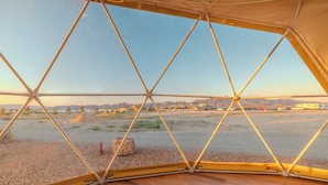 A geodesic dome structure with a view of a desert landscape and distant mountains. - Tirrito Farm (Willcox)