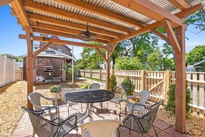 Enjoy dining and socializing in this shaded patio area with a barbecue grill and comfortable seating for four.