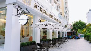 An outdoor seating area with tables and chairs, a sign for 'SC Restaurant, Coffee & Wine', and a 'Marble Lounge' sign. - SC Luxury Hotel (Bai Chay)