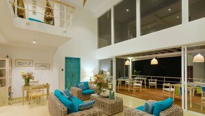 A spacious living area with wicker furniture, a dining area, and a balcony with a view. - 33 Lake Terrace  (Hikkaduwa)