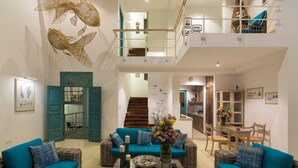 A spacious living area with wicker furniture, a staircase, and a dining area. - 33 Lake Terrace  (Hikkaduwa)
