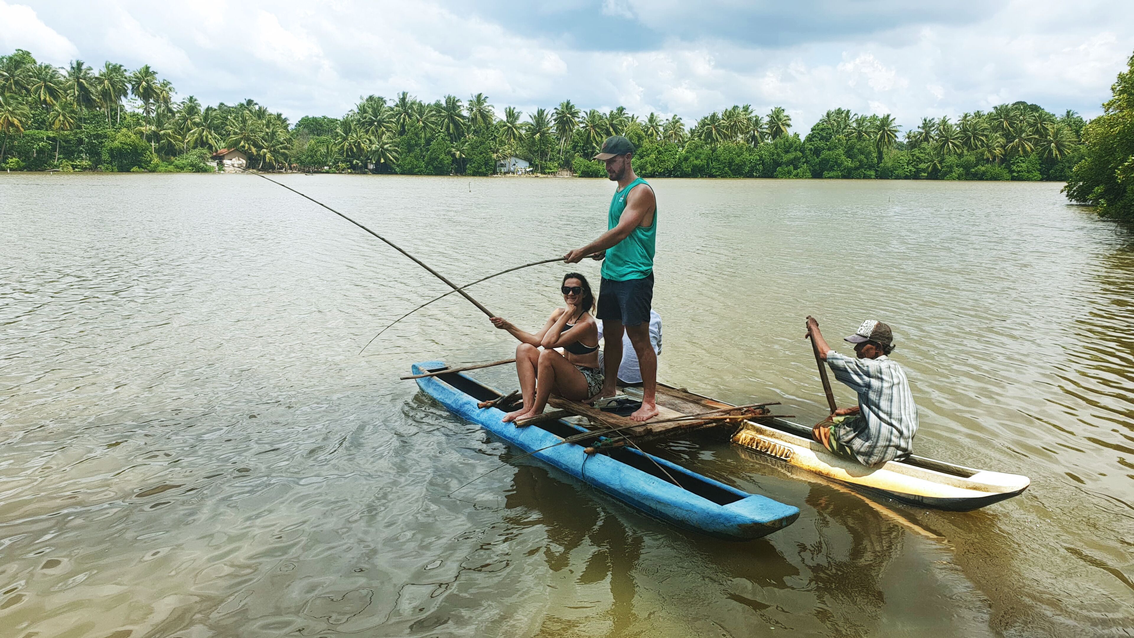 Un groupe de personnes se trouve à bord d’un petit bateau sur une étendue d’eau calme, entourée d’une végétation luxuriante.