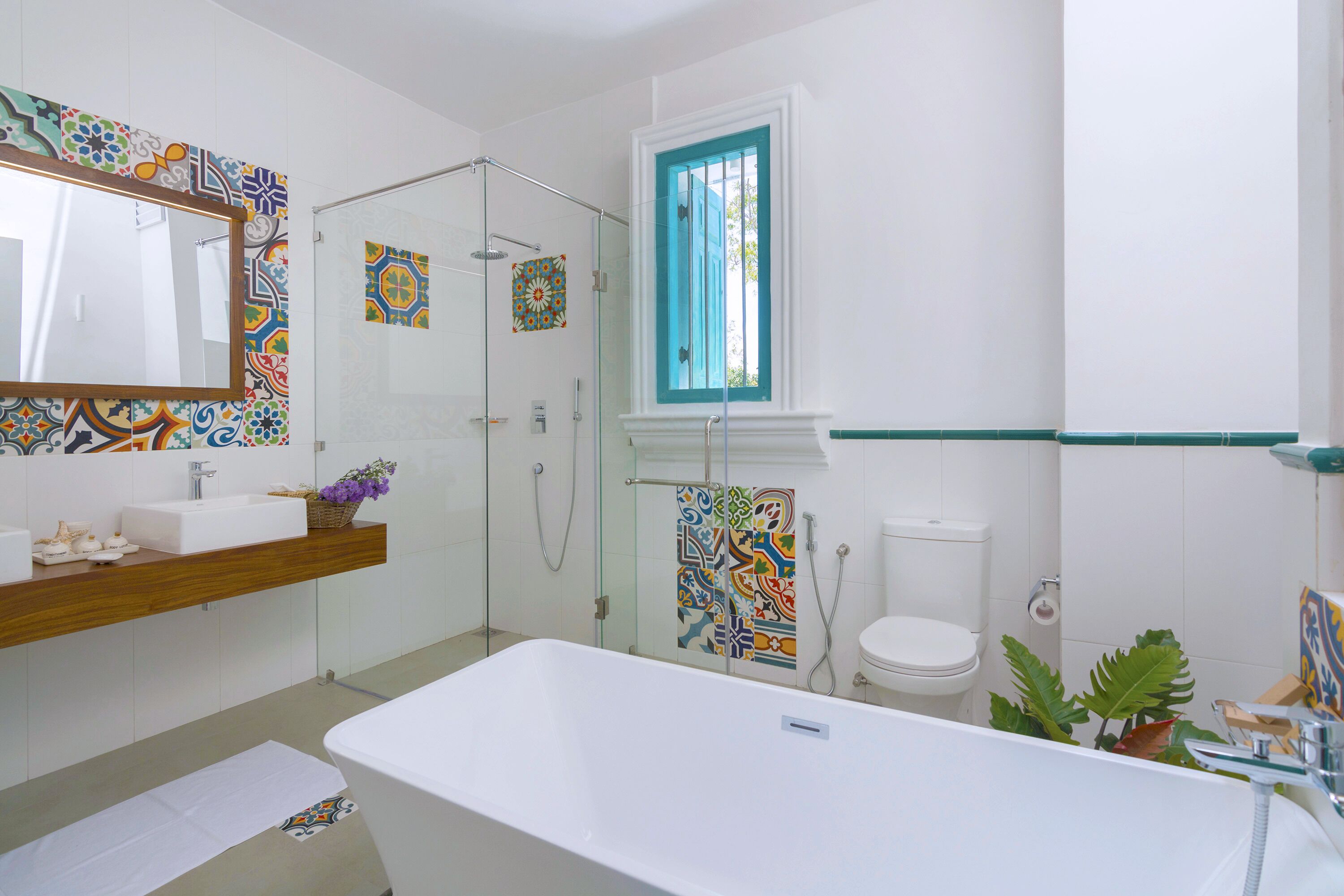 Een moderne badkamer met een vrijstaand bad, een douche met glazen wanden en een toilet.
