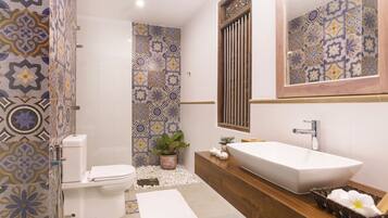 Une salle de bain avec des toilettes, une douche et un lavabo.