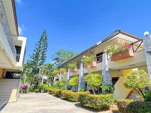 A hotel with a central courtyard, multiple floors, and a mix of modern and traditional architecture. - Sea View Resort Rayong (Rayong)