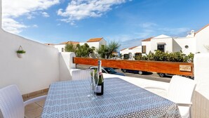A balcony with a table set for two, a bottle of wine, and a car parked in the background. - Port Royale shine and bright, heated pool (Los Cristianos)