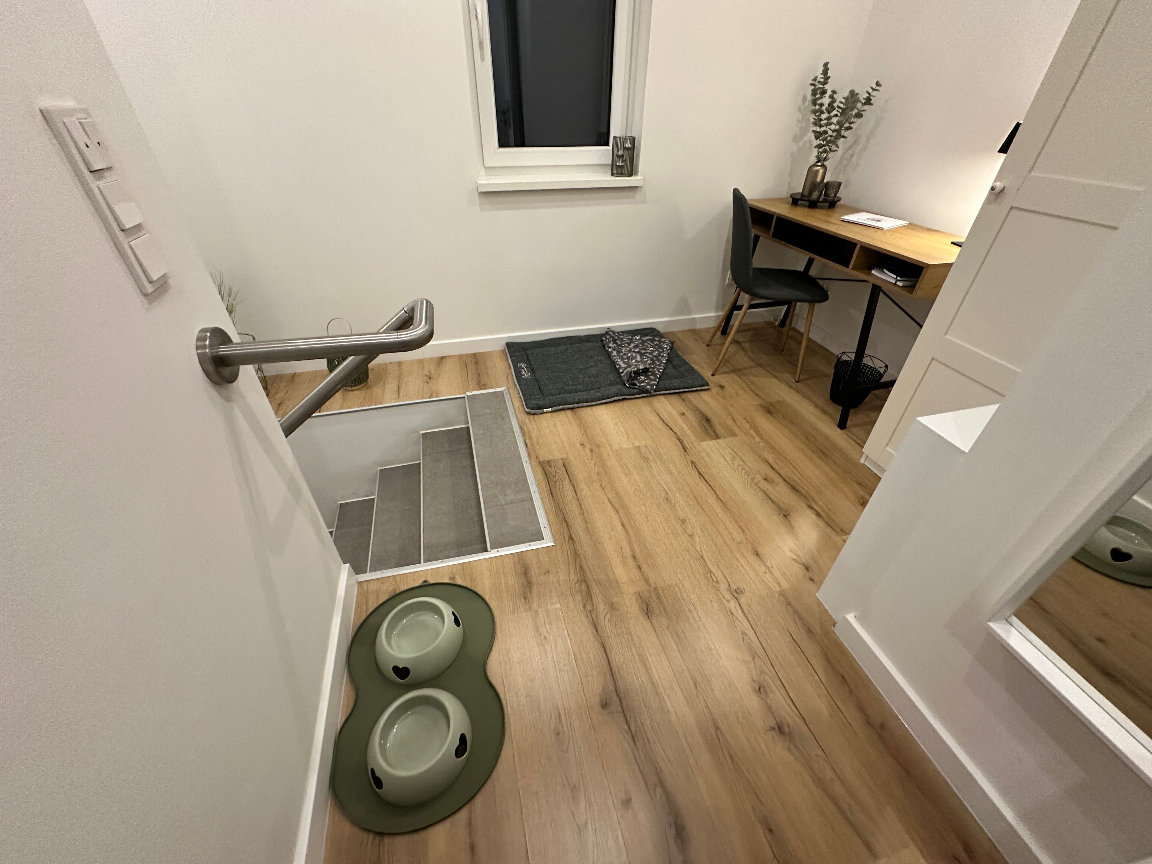 Uma casa de banho pequena e moderna com chuveiro, sanita e lavatório, além de uma janela.