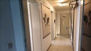 A hallway with tiled flooring, doors, and a light fixture. - Apartment 'Bamboleo' with Shared Terrace, Private Garden and Wi-Fi (Veringendorf)