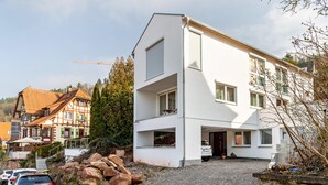 A modern two-story building with a white facade, a driveway, and a construction crane in the background. - Studio Apartment ' In der Stadt und Natur' with Wi-Fi (Calw)