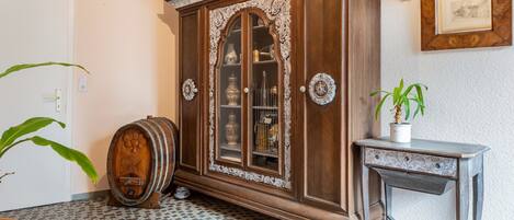 A room with a large wooden cabinet, a small table, and a potted plant.
