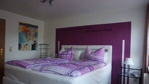Ein Schlafzimmer mit einem Bett, einem Nachttisch, einer Lampe und einer Wand mit einer Textnachricht.