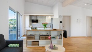 Ein modernes Wohnzimmer mit Sofa, Couchtisch und Bücherregal.