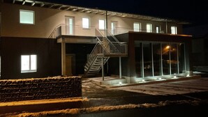 Een gebouw met een trap, meerdere ramen en een overdekt gebied met verlichting.