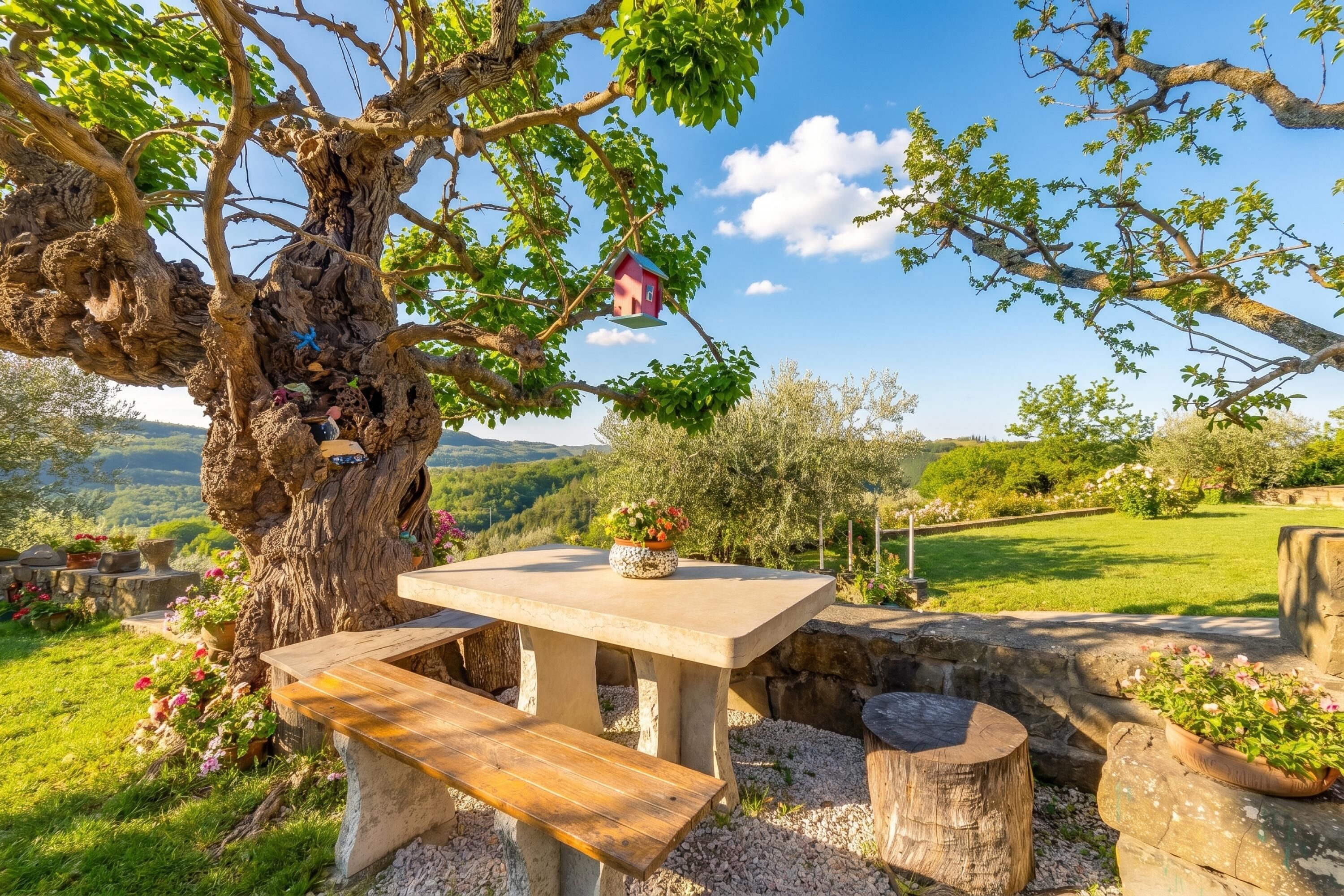 A stone table with benches, a birdhouse, and potted plants in a garden setting.