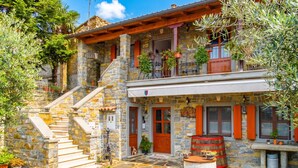 A stone building with a balcony, outdoor seating, and a staircase leading to the entrance. - Tourist Farm Tonin Apartments (Koper)