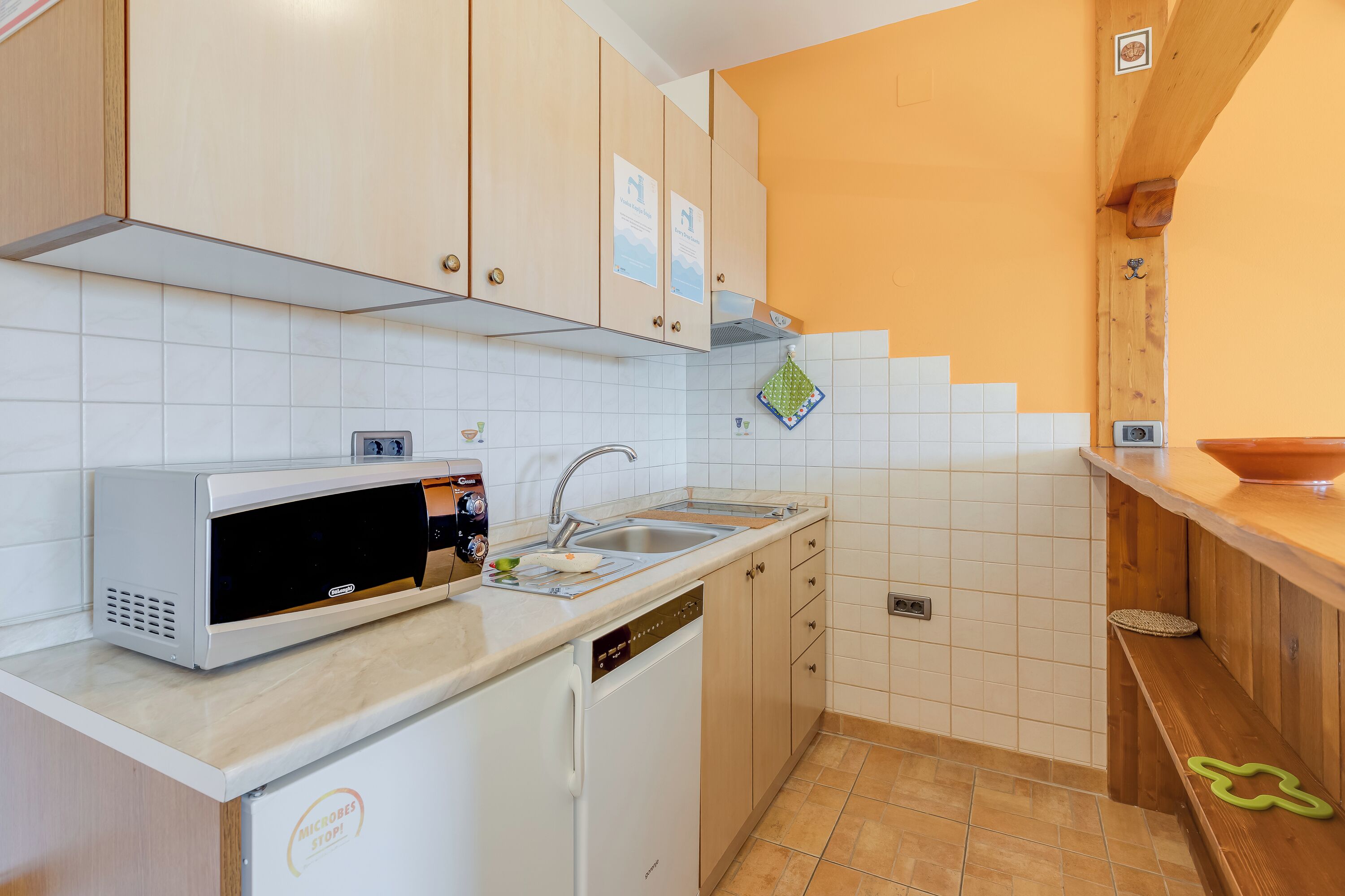 A compact kitchen with a microwave, sink, and dishwasher.