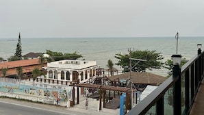 Vista costera con un restaurante y un edificio blanco con arcos.