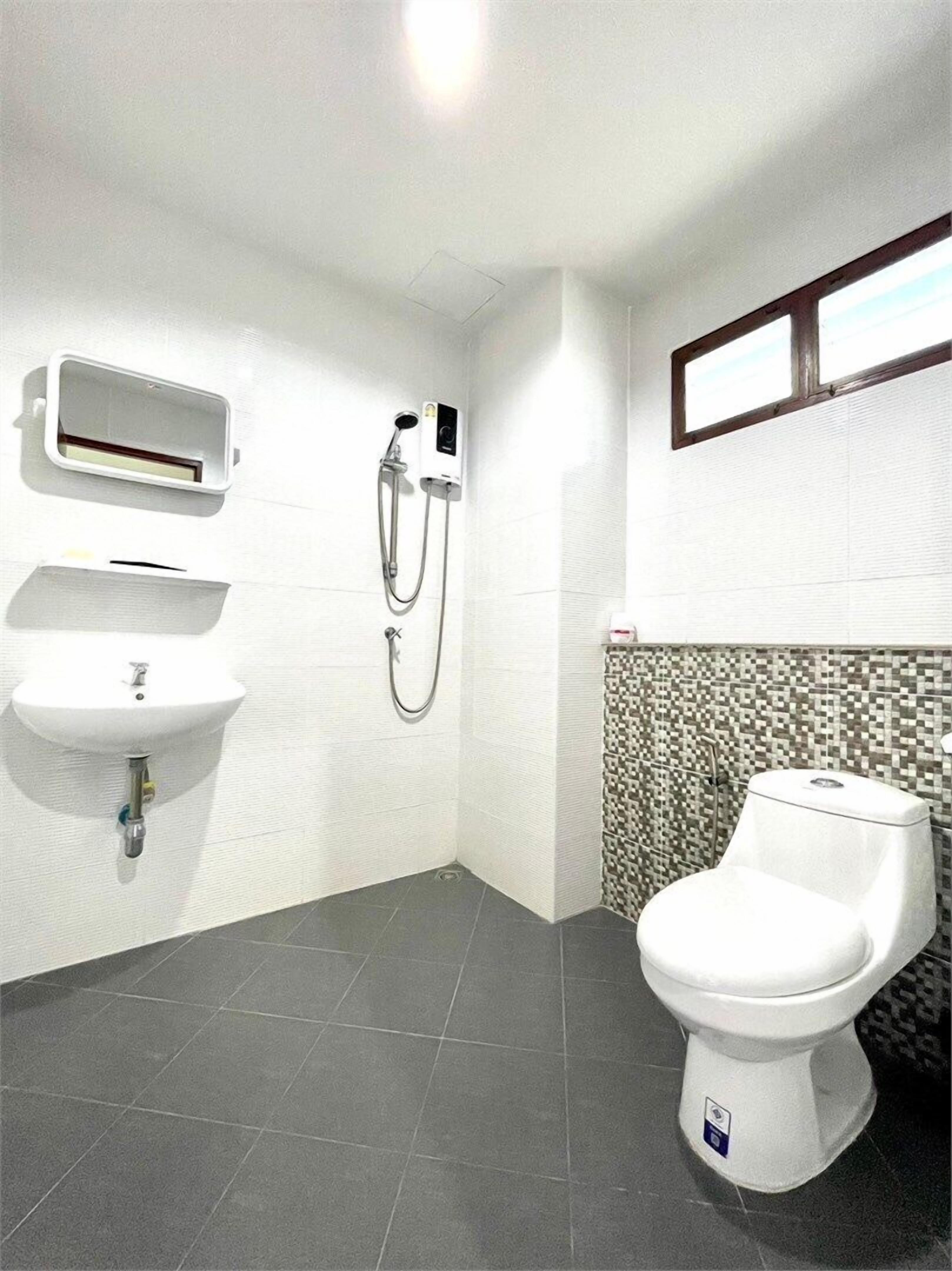 A bathroom with a white sink, a toilet, and a shower.