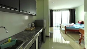 Una habitación de hotel moderna con cocina, una cama y un baño.