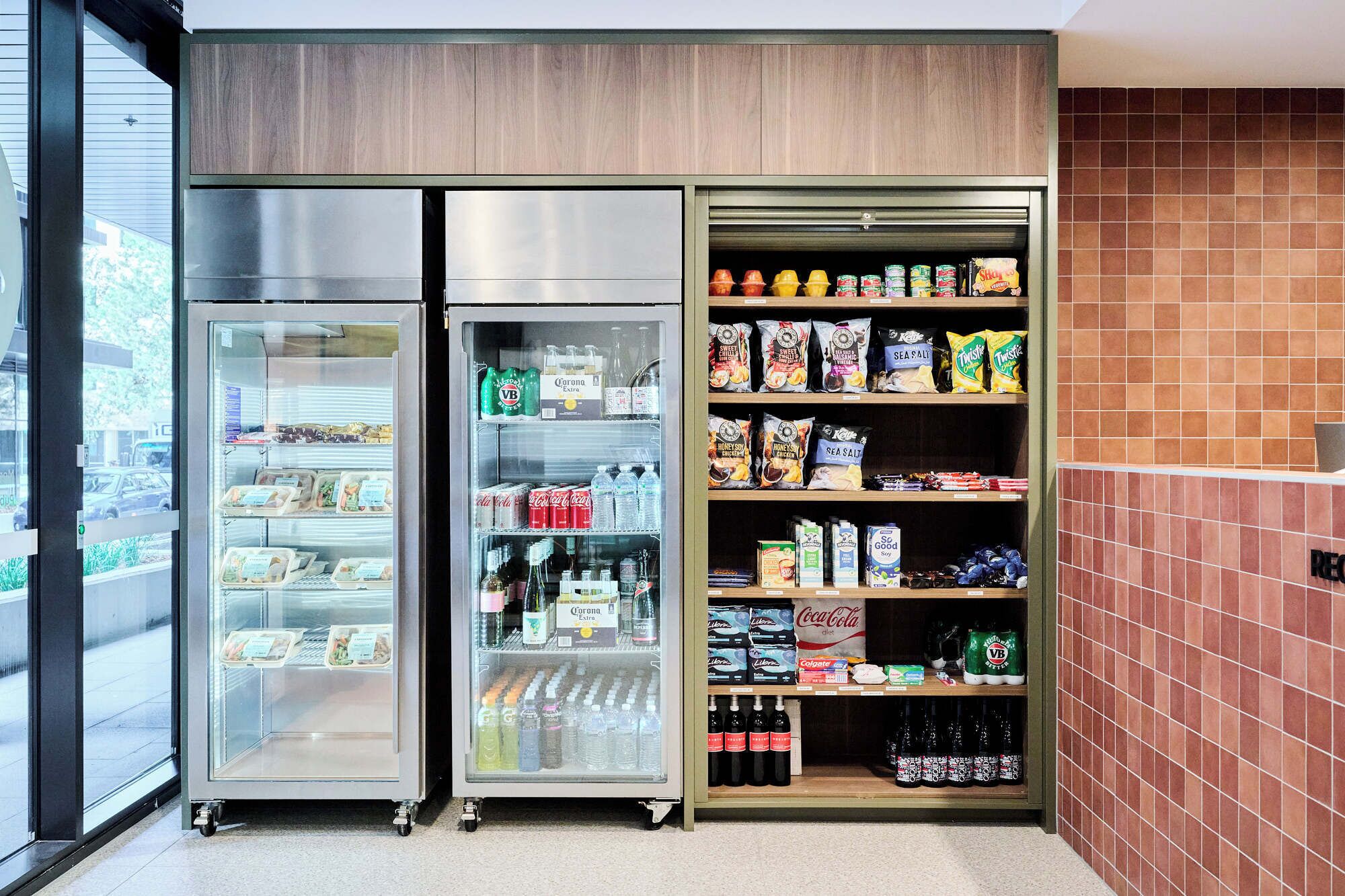 A refrigerated display case with a variety of food items and beverages, including snacks and bottled drinks.