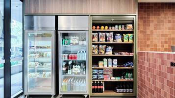 A refrigerated display case with a variety of food items and beverages, including snacks and bottled drinks.
