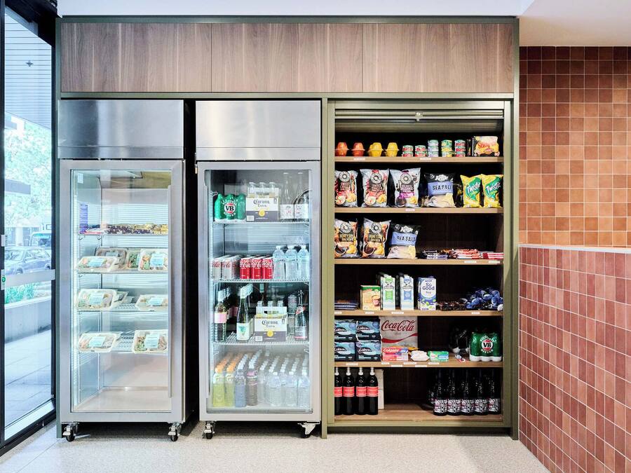 A refrigerated display case with a variety of food items and beverages, including snacks and bottled drinks.