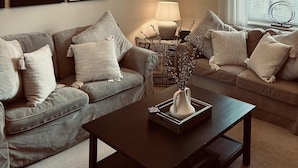 A living room with two sofas, a coffee table, a lamp, and abstract wall art. - Immaculate 1-bed Cottage in Moreton in Marsh (Moreton-in-Marsh)