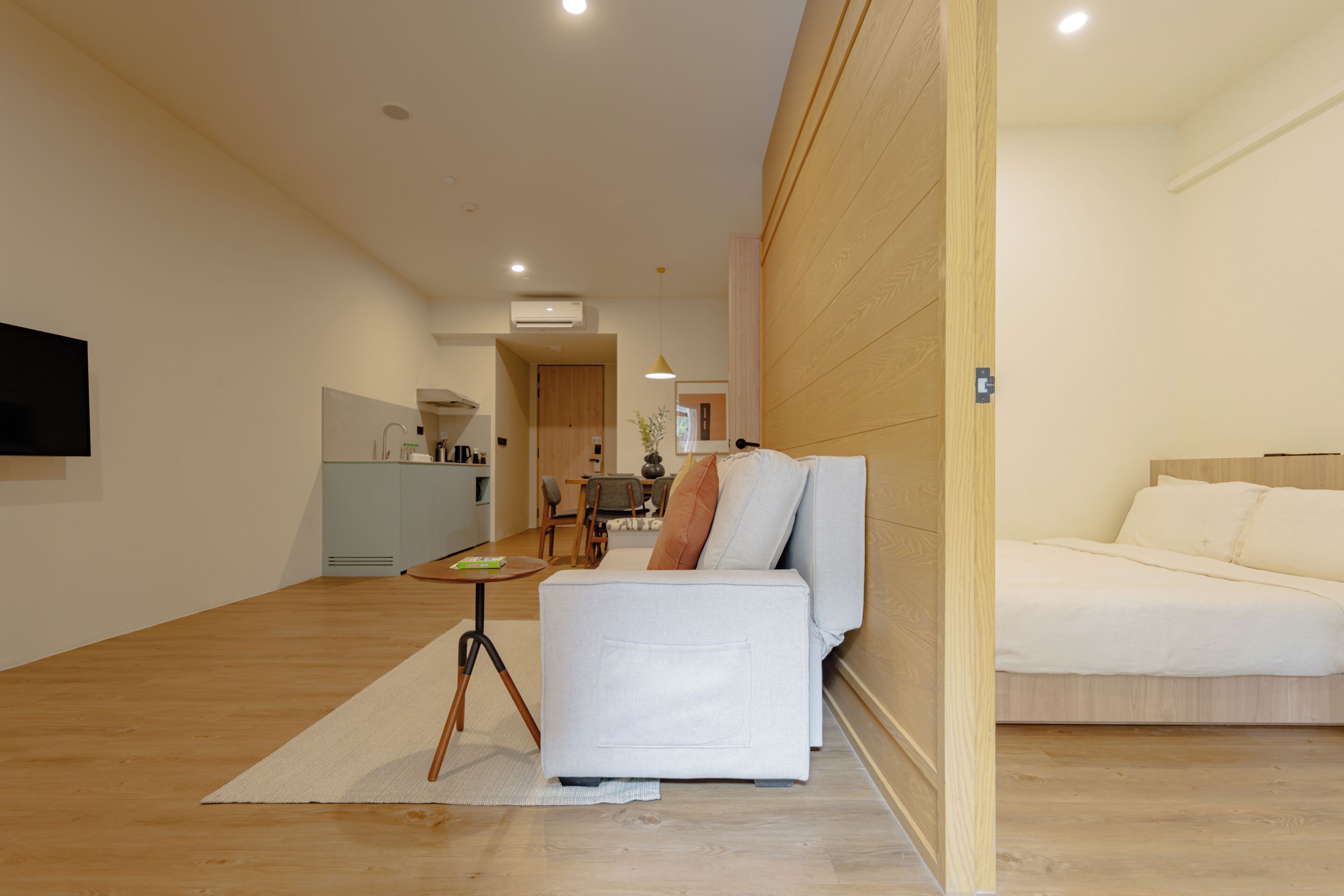 Ein modernes Wohnzimmer mit Sofa, Essbereich und Küche.