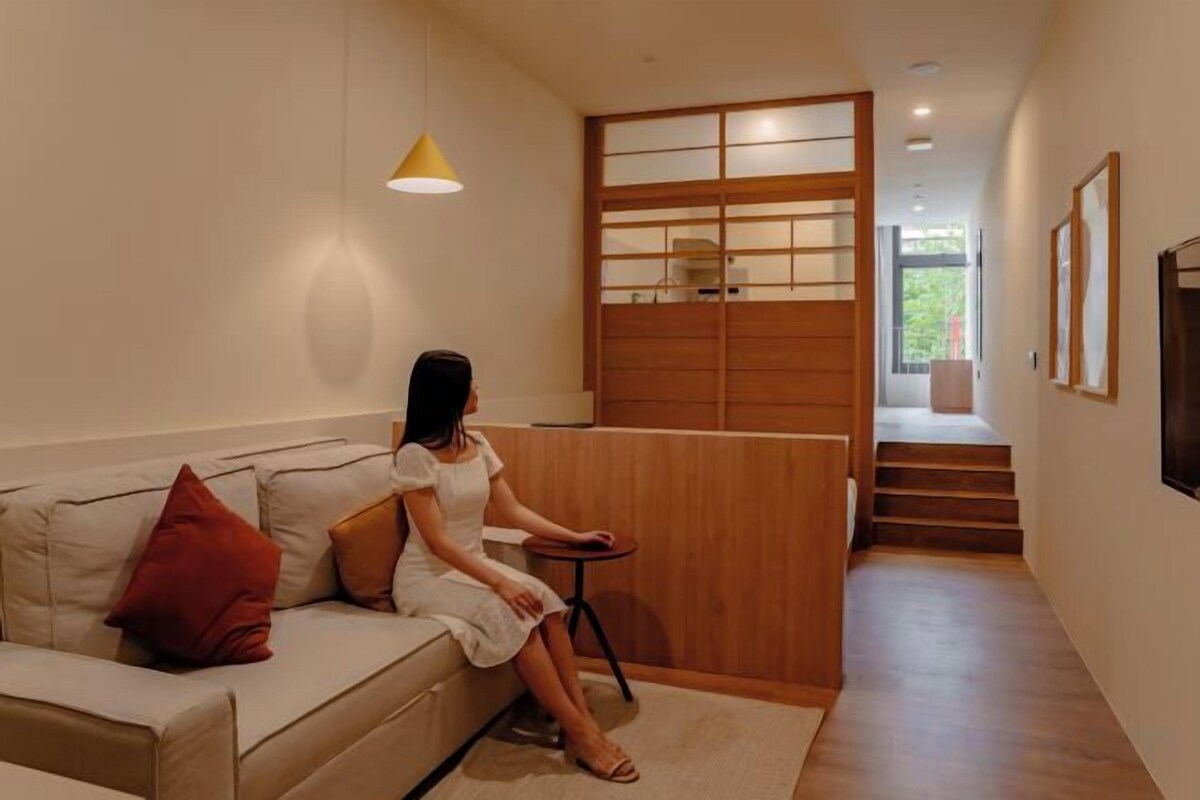 A modern interior with a sofa, a small table, and a staircase leading to an upper level.