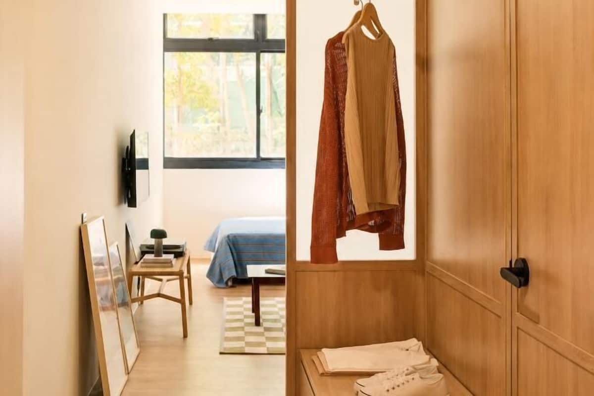 Un pasillo con una cama, un escritorio y un armario.