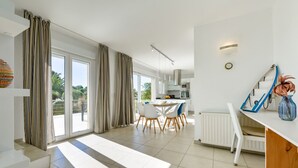 A modern living room with a dining area, large windows, and a view of the outdoors. - Villa for rent in Benissa, AZUR. (Benissa)