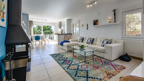 A spacious living room with a white sofa, a glass coffee table, and a colorful rug. - Villa for rent in Benissa, AZUR. (Benissa)