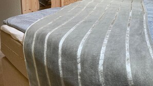 Un dormitorio con cama, armario de madera y ventana con cortinas.