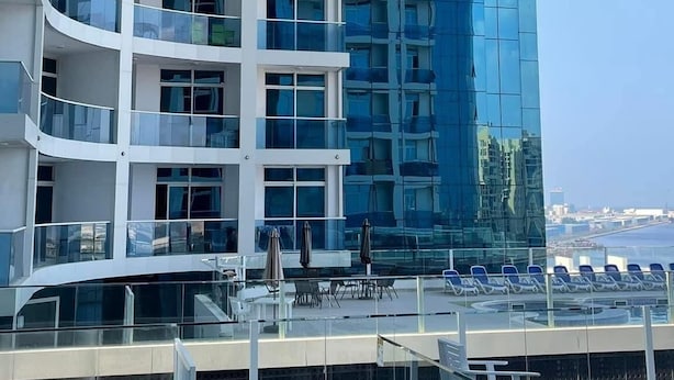 Un bâtiment moderne doté de nombreux balcons et d’une façade en verre.