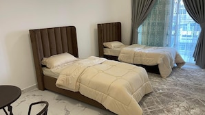 Une chambre d’hôtel avec deux lits, une petite table et une chaise.