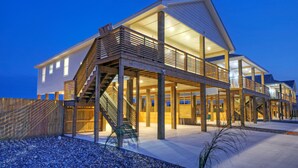 Una casa moderna amb diversos pisos, un balcó de fusta i una escala que condueix als nivells superiors.