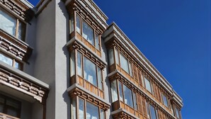 Un edificio de varios pisos con fachada simétrica, ventanas amplias y una entrada destacada con puerta de madera.