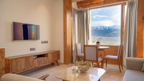 Una sala de estar moderna con un ventanal grande, muebles de madera y un televisor de pantalla plana.