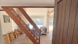 A spacious hallway with a wooden staircase leading to a living area. - Villa San Michele - 70's Experience (Salernes)
