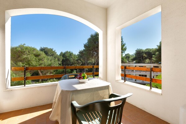 A balcony with a table and chairs, overlooking a scenic landscape with trees and a clear sky. - 3736 Appartamento Fiorita by Barbarhouse (Vernole)