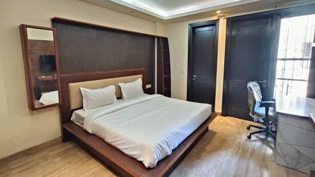 Ein Schlafzimmer mit einem Bett, Deckenventilator, Schreibtisch und Stuhl.