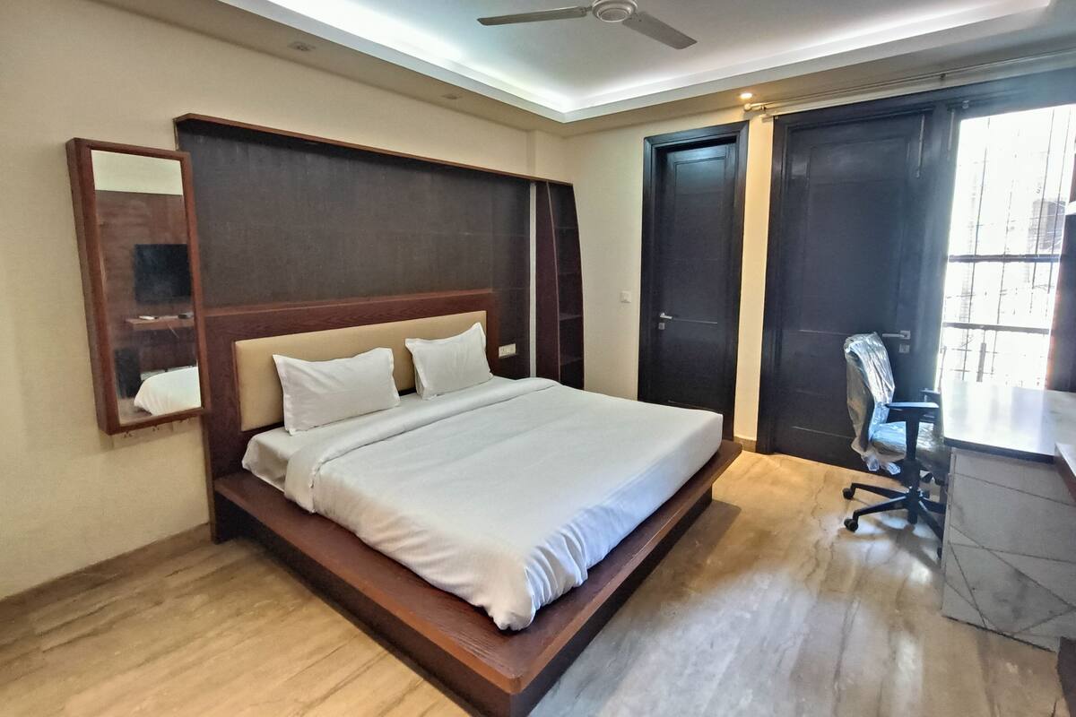 Ein Schlafzimmer mit einem Bett, Deckenventilator, Schreibtisch und Stuhl.