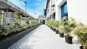 A pathway leading to the Madhav Residency Hotel with potted plants on either side. - Madhav Residency Hotel & Banquet, Kalyan, Mumbai (Thane)