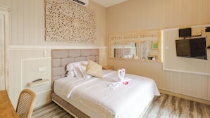 A hotel room with a large bed, a television, a mirror, and a decorative wall piece. - Rustic Pandawa Villa (Kutuh)