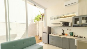 A modern kitchen with grey cabinets, a built-in microwave, and a sink. - Rustic Pandawa Villa (Kutuh)