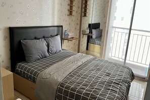 A modern bedroom with a large bed, a bedside table with a water bottle and towels, a mirror, and a balcony view. - Day Use Inn At Serpong Green View Apartment Bsd (South Tangerang)